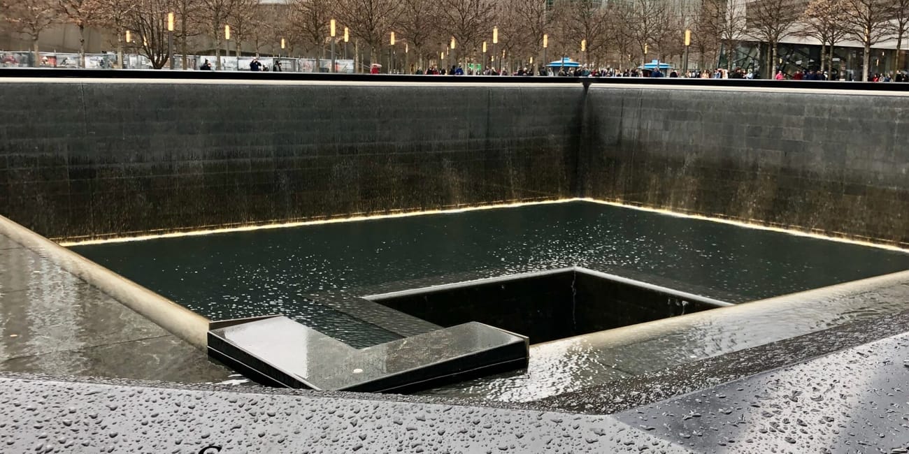 Memoriały 9/11 memorial pools w nowym jorku z nazwiskami ofiar na krawędzi i otaczającymi wieżowcami