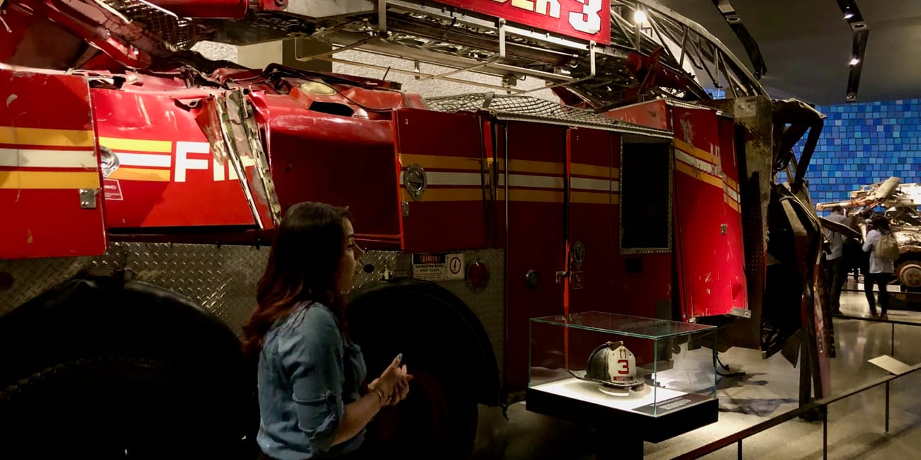 Nowojorskie 9/11 museum z uszkodzoną czerwoną strażacką drabiną ladder 3 i hełmem w gablocie