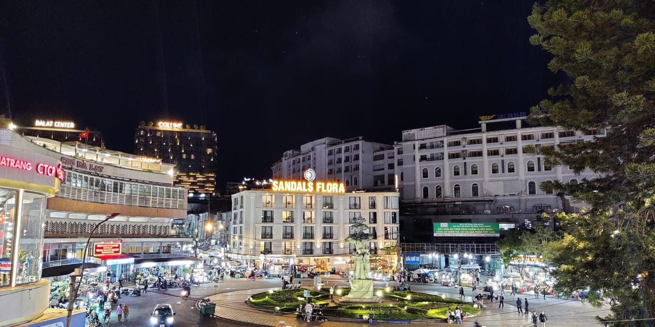 Wieczorny plac w centrum da lat z pomnikiem i oświetlonymi budynkami wokół