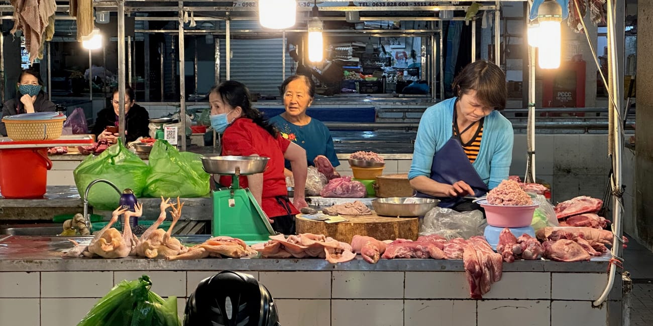 Stoisko z surowym mięsem na targu da lat market w wietnamie, obsługiwane przez kilka kobiet.