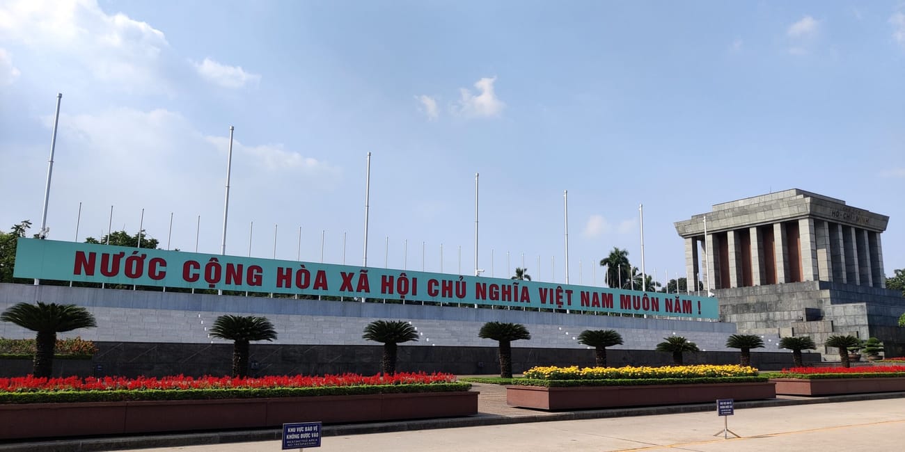 Mauzoleum hồ chí minha w hanoi z napisem na fasadzie i kwietnymi rabatami
