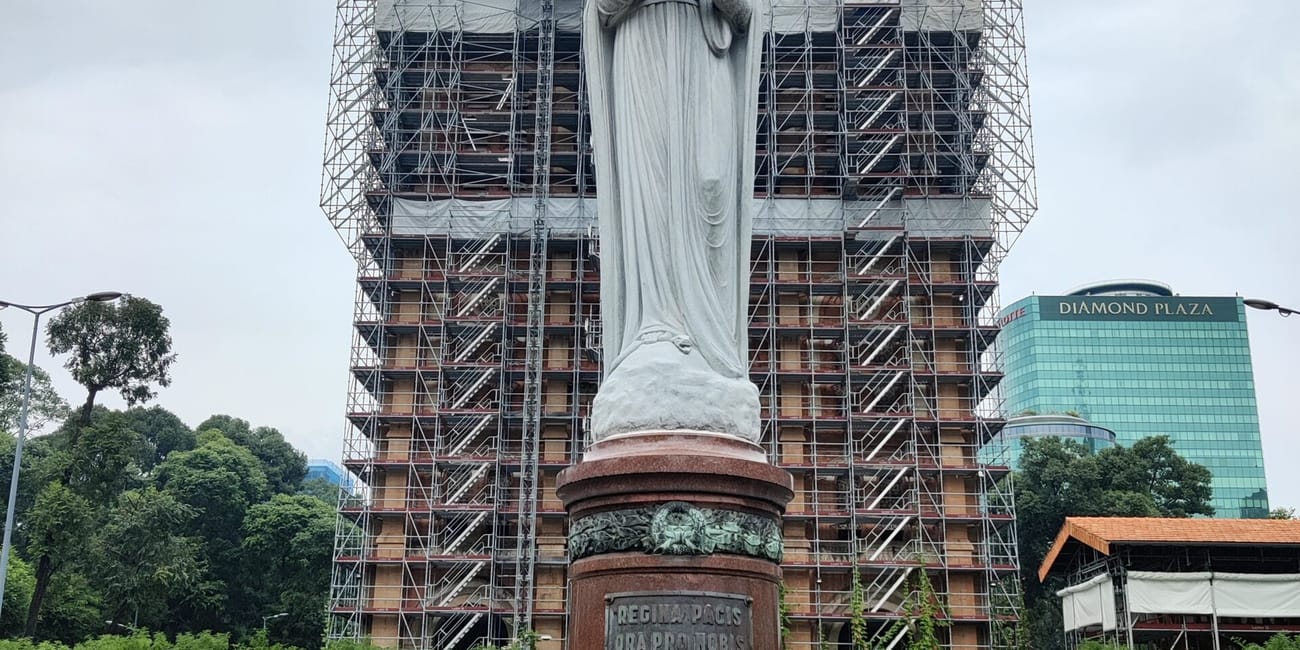 Posąg matki boskiej przed katedrą notre dame w ho chi minh, w rusztowaniach remontowych
