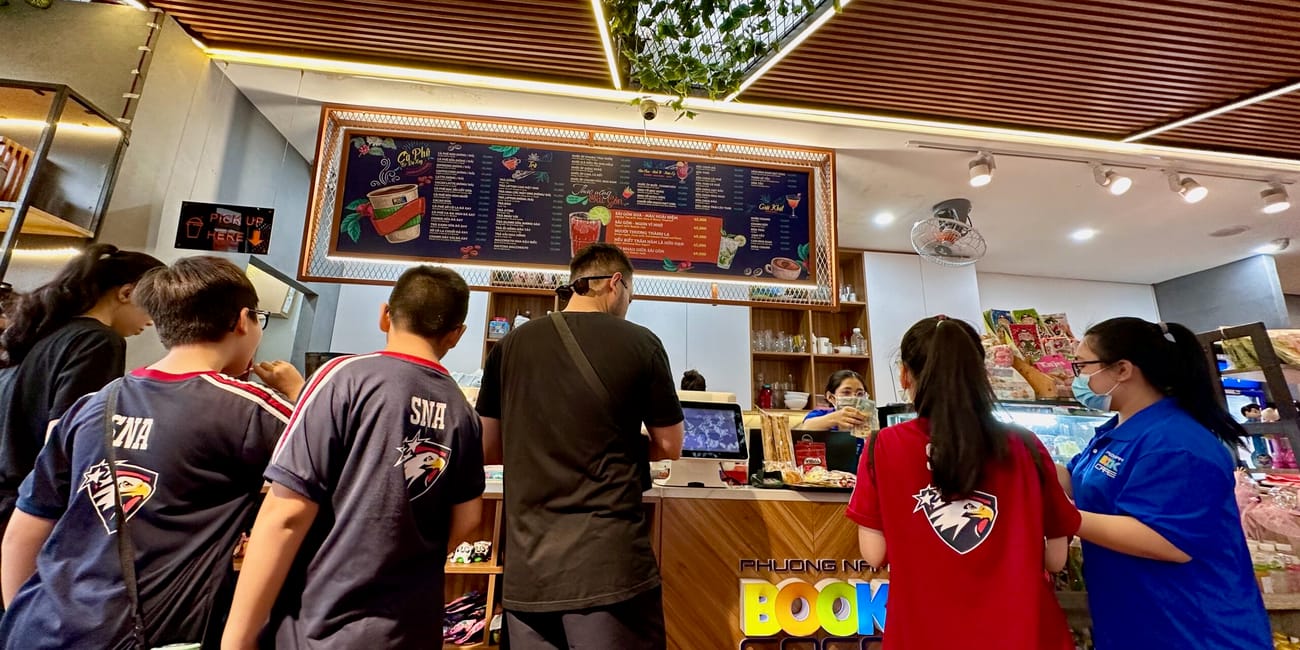 Book street w ho chi minh z klientami przy ladzie kawiarni i menu nad kasą