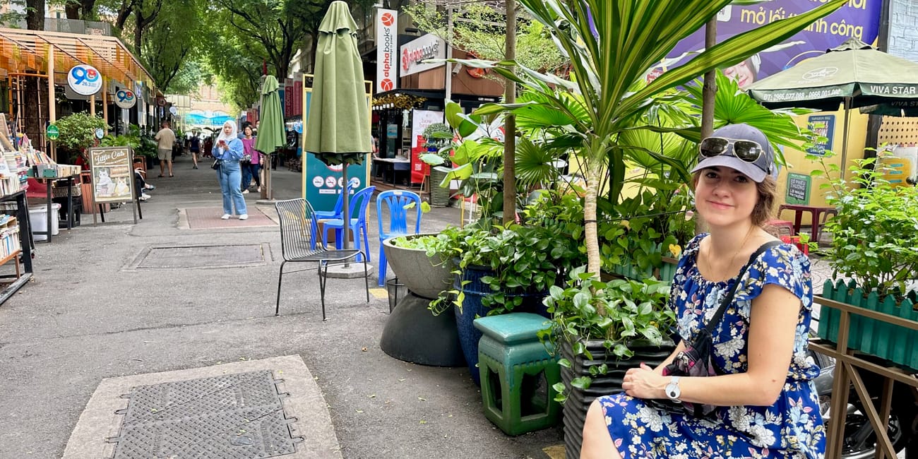 Kobieta siedzi przy roślinach na ho chi minh book street w wietnamie.