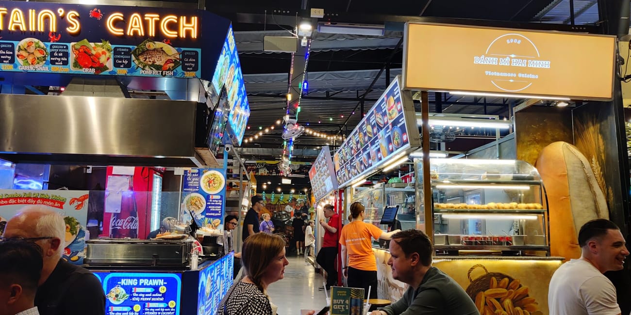 Targ ho chi minh ben nghe street food z kramami z jedzeniem i siedzącymi gośćmi w nocy