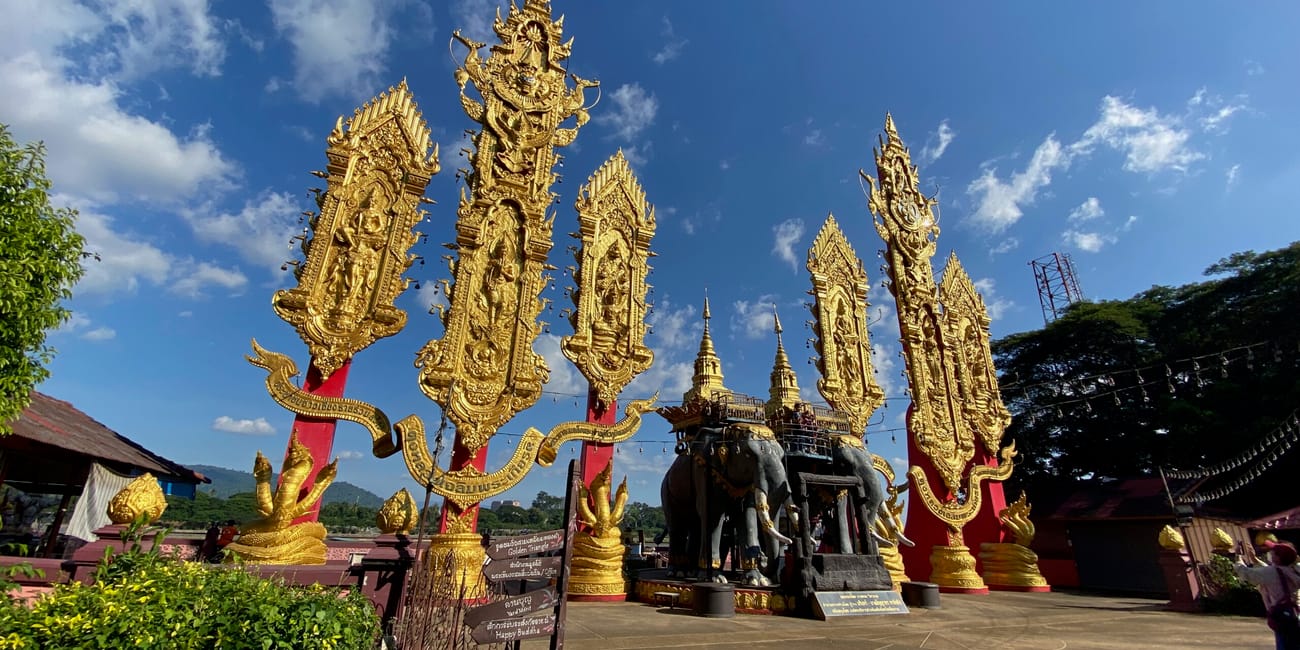 Złote zdobione wieże i posągi przy chiang rai golden triangle w tajlandii