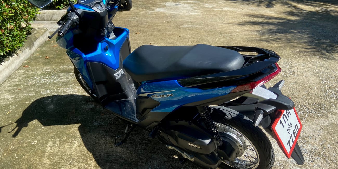 Niebieski skuter honda click zaparkowany na słońcu w phuket, tajlandia.