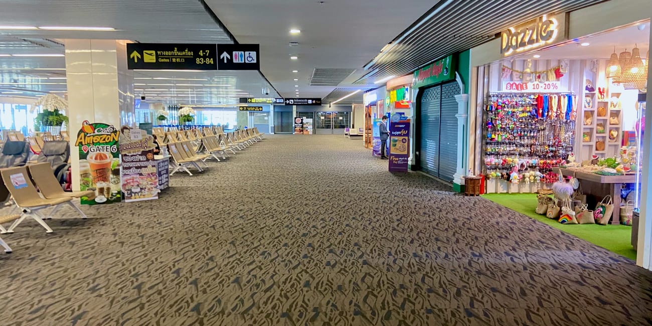 Korytarz w terminalu lotniska na phuket z pustymi siedzeniami i sklepikami