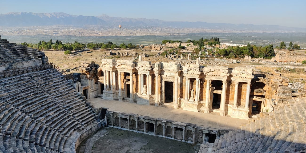 Antyczny teatr hierapolis w pamukkale z widokiem na ruiny i góry w tle