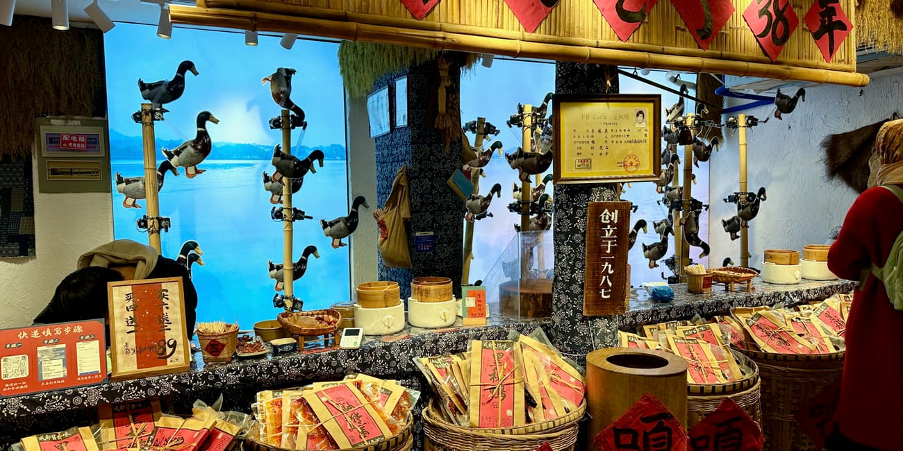 Sklepik na chengdu jinli street z koszami wyrobów i ozdobami z kaczek na bambusowych słupach.