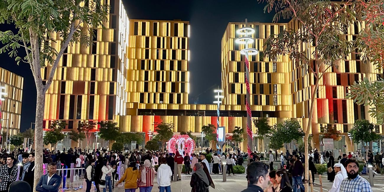 Lusail boulevard w doha nocą, z podświetlonymi wieżowcami i tłumem spacerujących ludzi