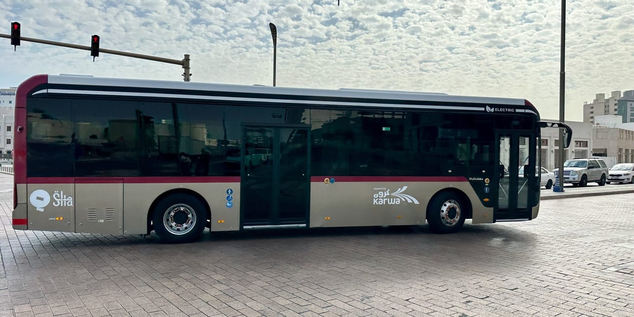 Elektryczny autobus karwa na ulicy w doha, qatar, przy czerwonym świetle
