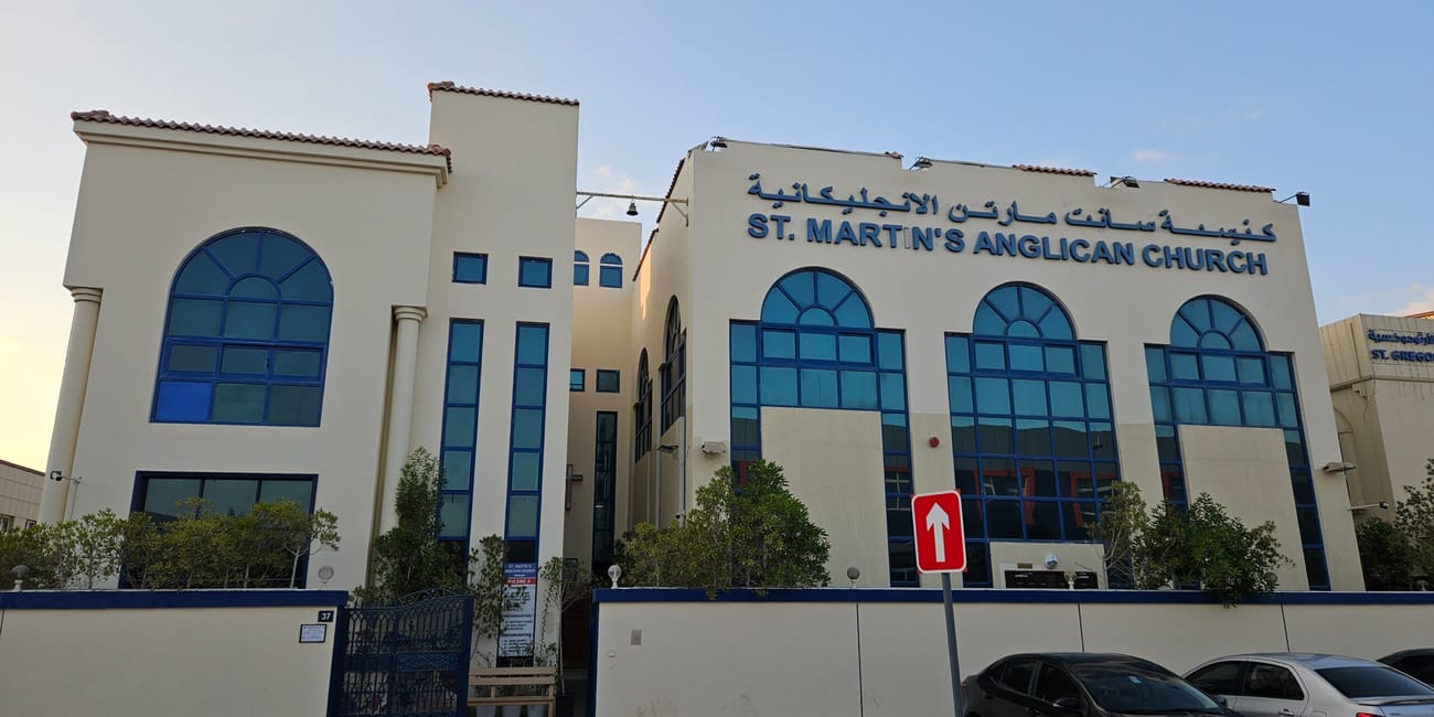 Kościół anglikański st. Martin’s w szardży z niebieskimi oknami i zaparkowanymi samochodami