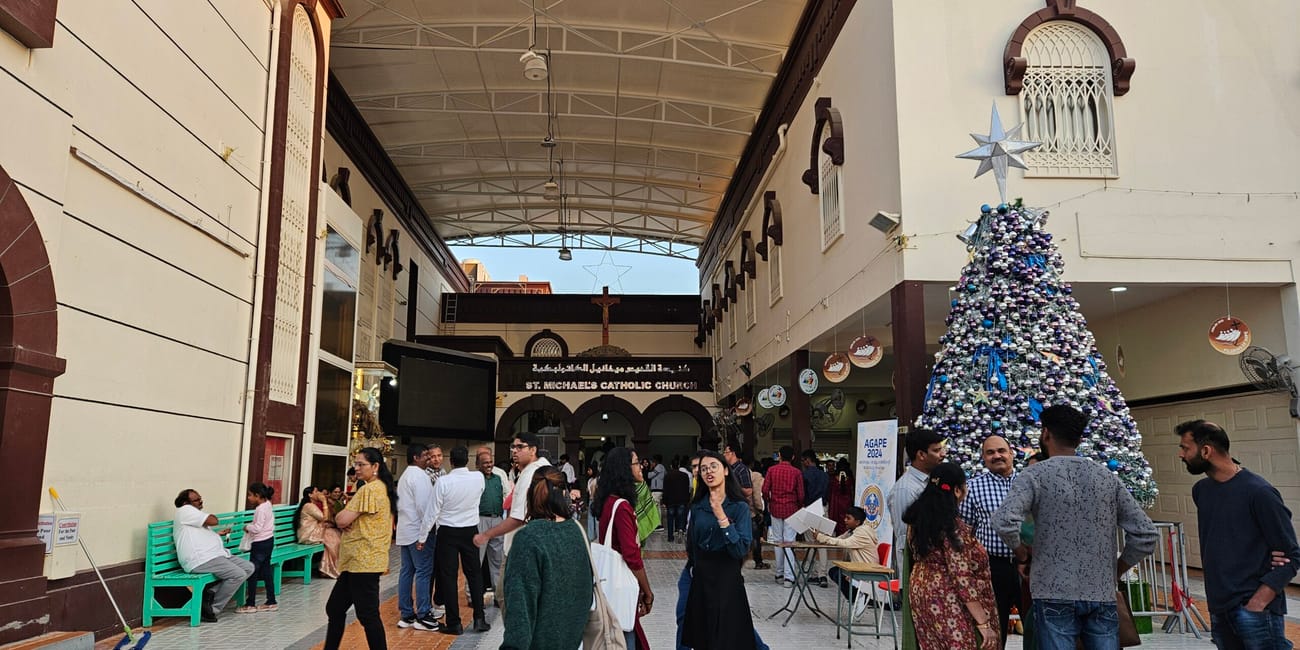 St. Michael’s catholic church w sharjah z choinką i grupą ludzi na dziedzińcu