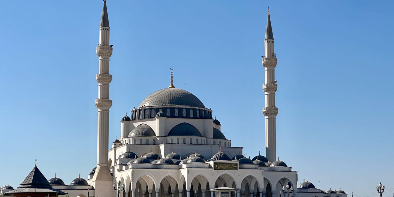 Meczet sharjah w zea z dwiema wysokimi minaretami i dużą kopułą.