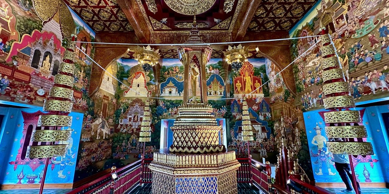 Wnętrze wat chedi luang w chiang mai z bogato zdobionym ołtarzem i malowidłami ściennymi