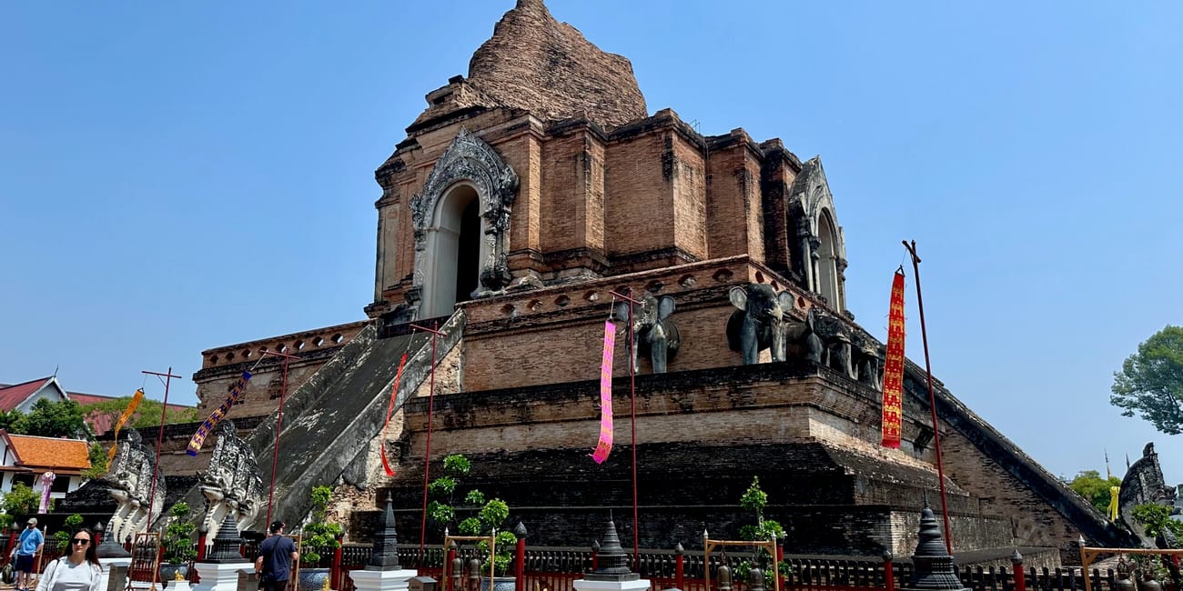 Świątynia w chiang mai z ceglanym chedi i schodami pod błękitnym niebem