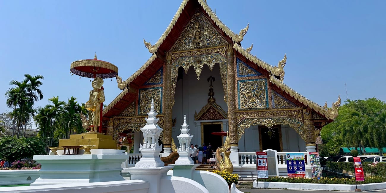 Wat phra singh woramahawihan w chiang mai z ozdobną świątynią i złotym posągiem w słońcu