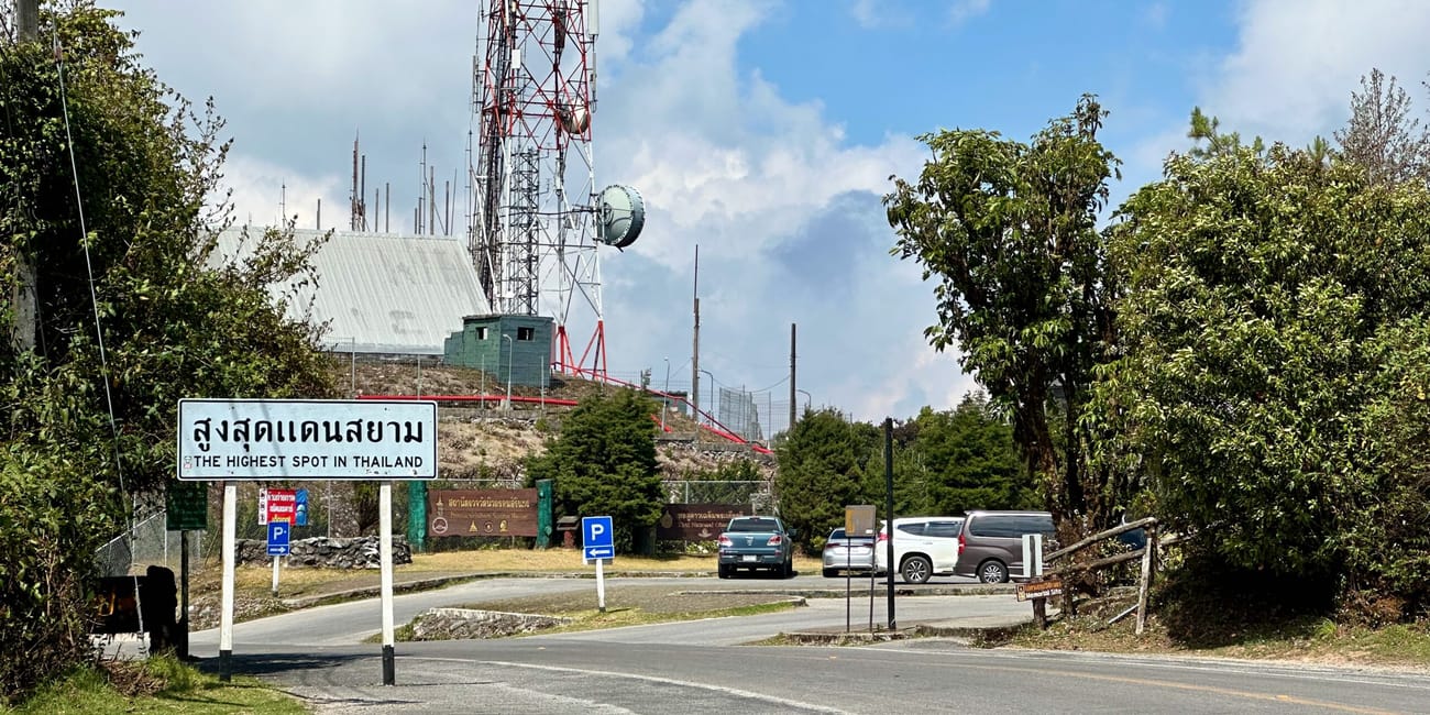 Doi inthanon w chiang mai: droga przy wieży telekomunikacyjnej i znak „the highest spot in thailand”.