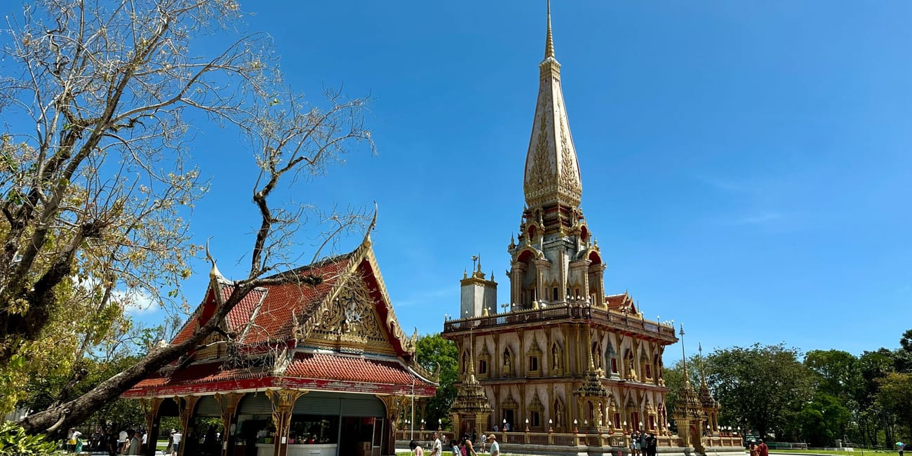 Wat chalong w phuket z ozdobną wieżą i świątynnym budynkiem pod błękitnym niebem