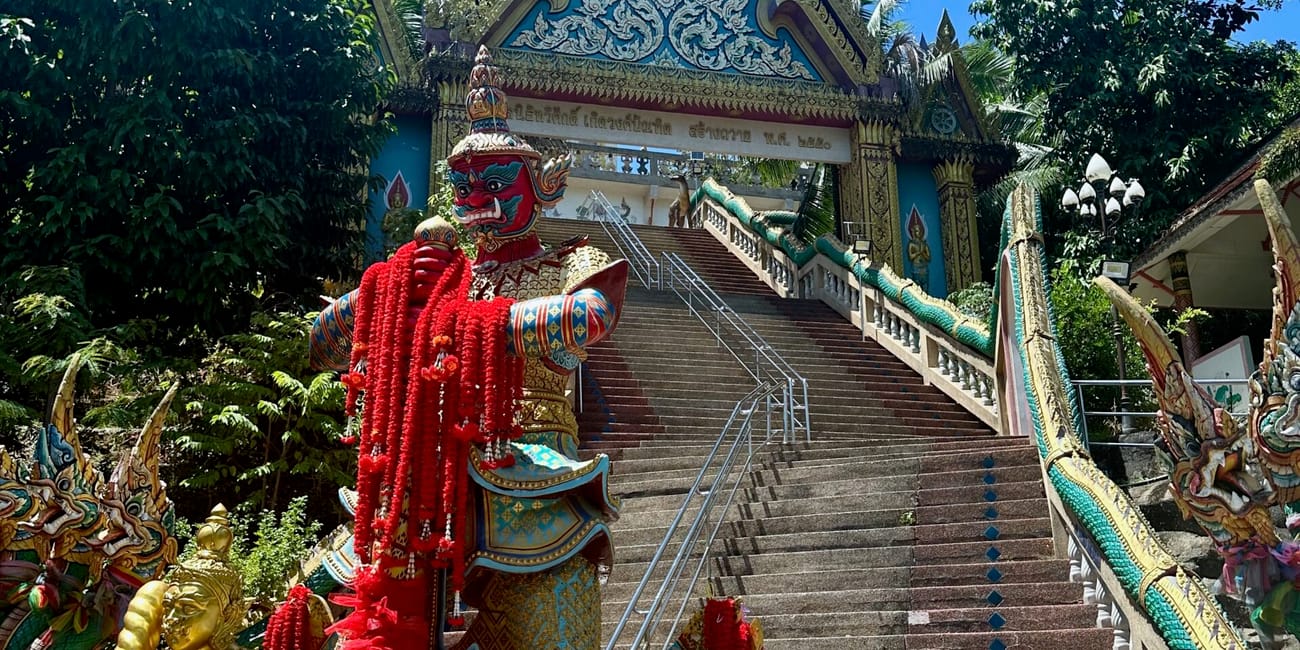 Wat khao rang samakkhitham w phuket, z ozdobnymi schodami i kolorowymi posągami świątynnymi