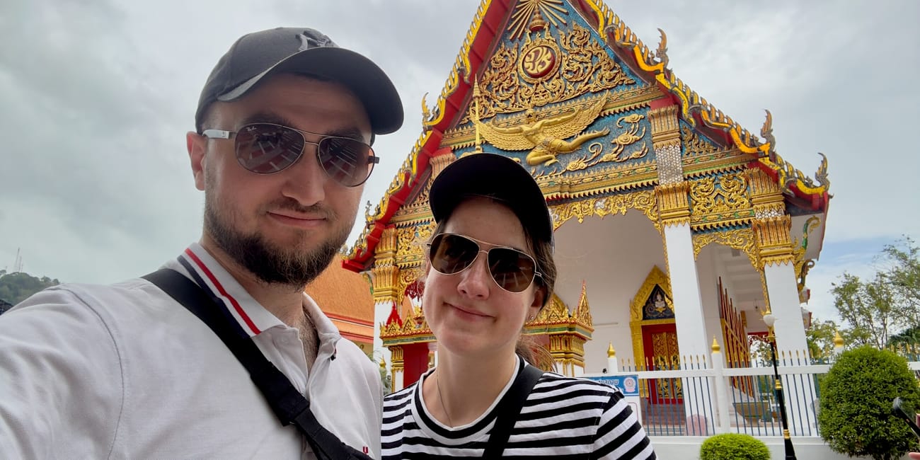Para na tle świątyni wat mongkolnimit w phuket, thailand.