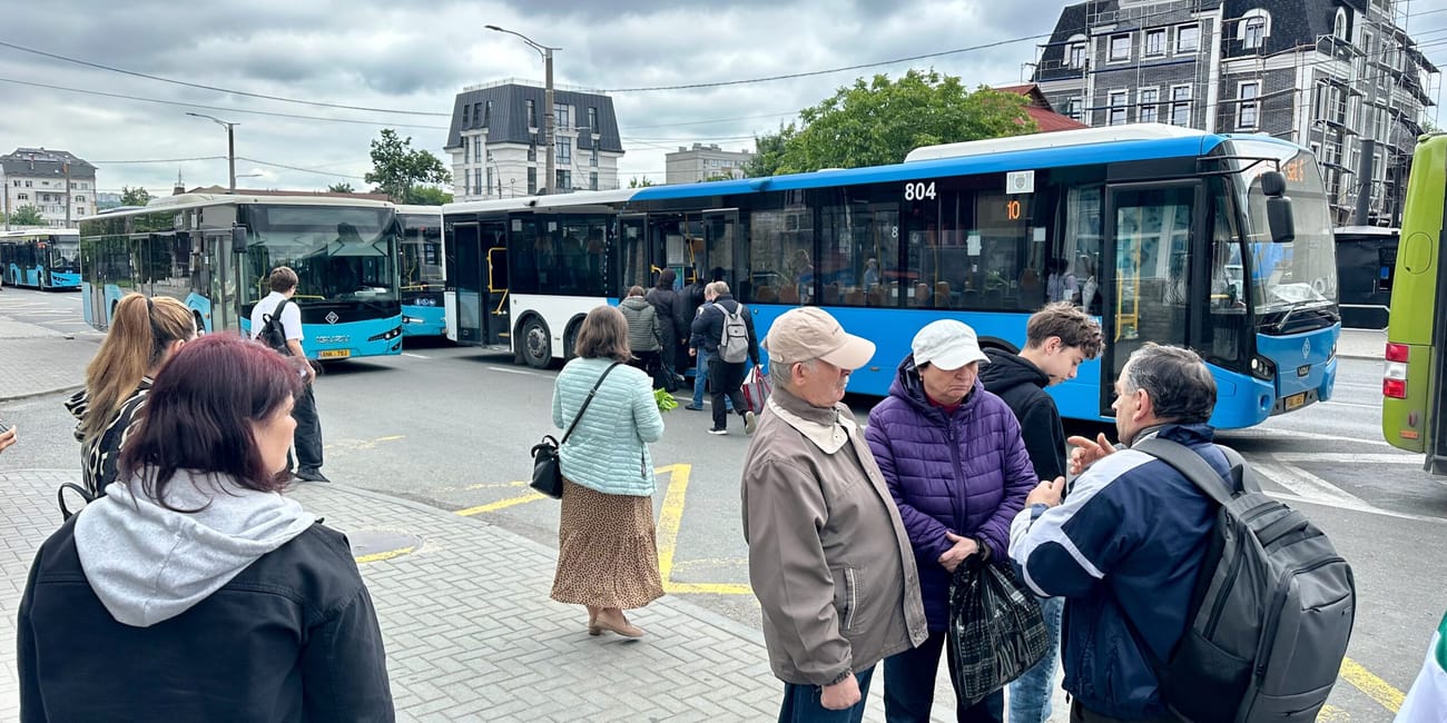 Chisinau public transport: commuters boarding a blue city bus on a cloudy day