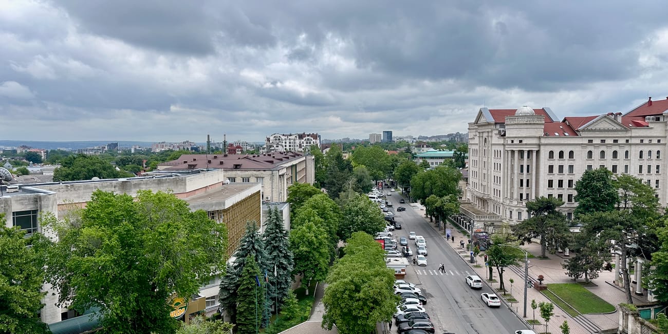 Widok z góry na okolice muzeum historii miasta kiszyniowa, ulicę i drzewa pod pochmurnym niebem