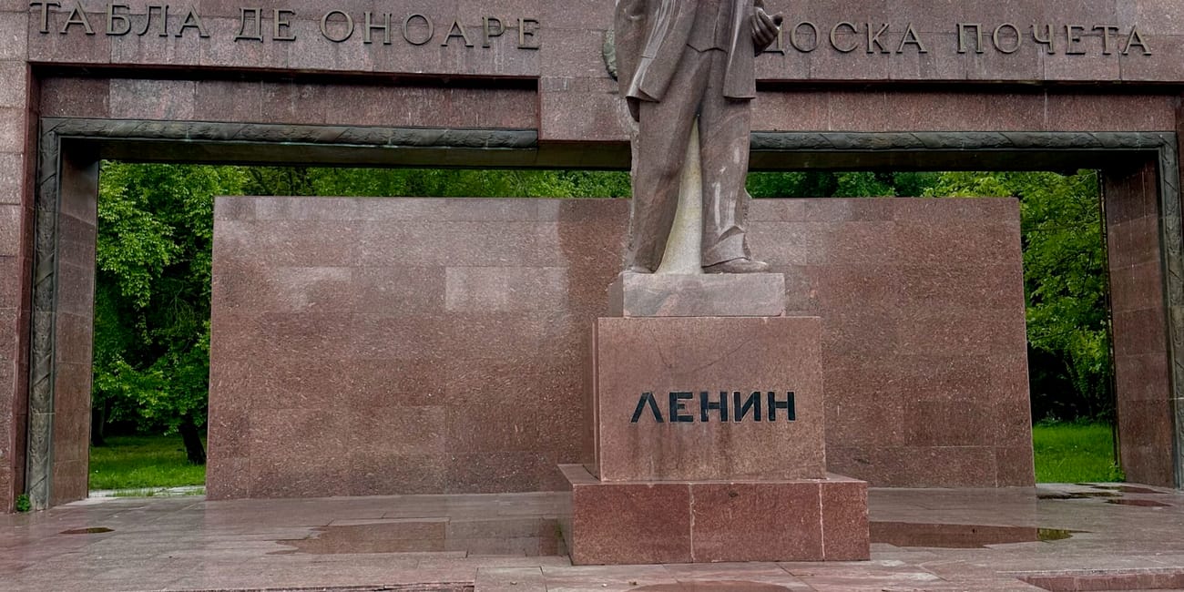 Pomnik lenina w chișinău, na czerwonym postumencie pod pochmurnym niebem.