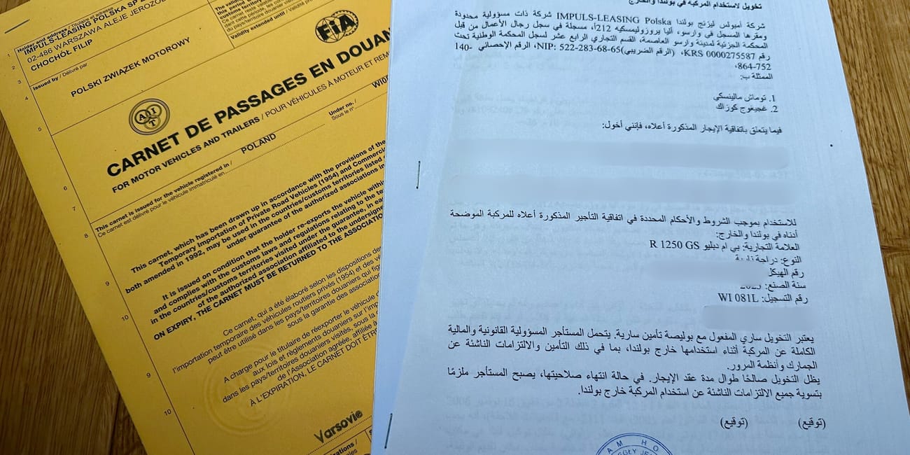 Dokumenty legalizacyjne pojazdu w iraku: żółty carnet i arabskie pismo z pieczęcią.