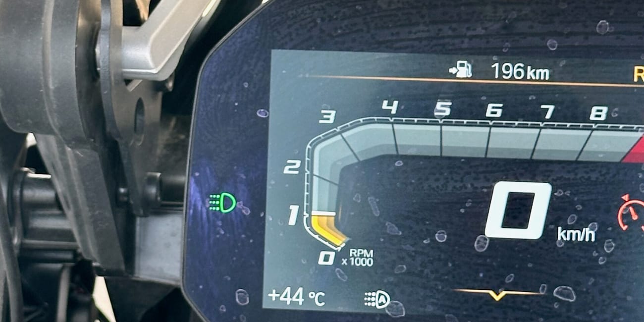 Kokpit motocykla ekspedycji desert horizons w iraku, z ekranem nawigacji i licznikiem na 0 km/h.