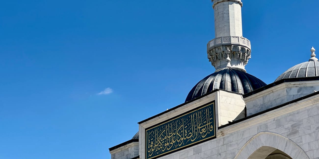 Ankara melike hatun mosque minaret and dome with ornate arabic inscription against a clear blue sky