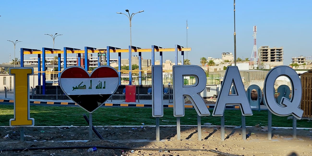 Tablica „i ♥ iraq” w bagdadzie na tle miejskiej zabudowy