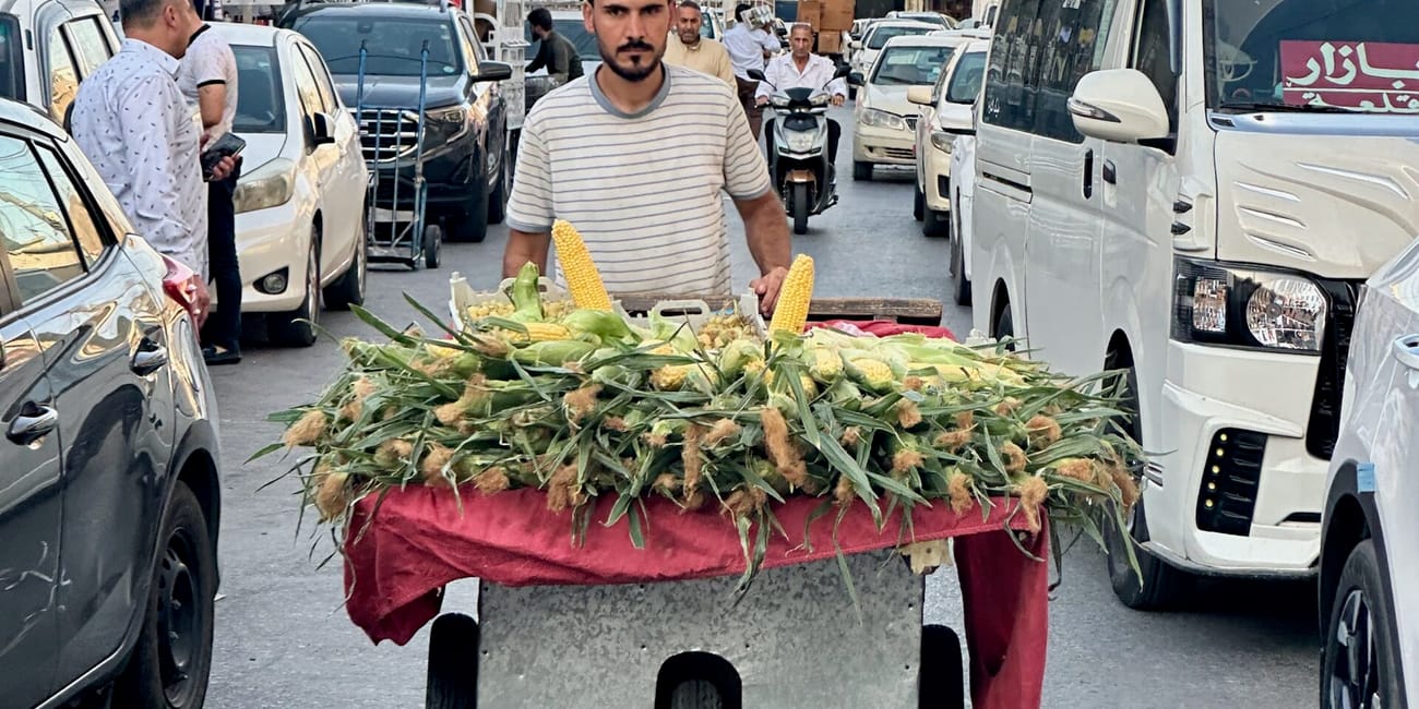 Uliczny sprzedawca kukurydzy na ruchliwej ulicy w erbilu, iraq.