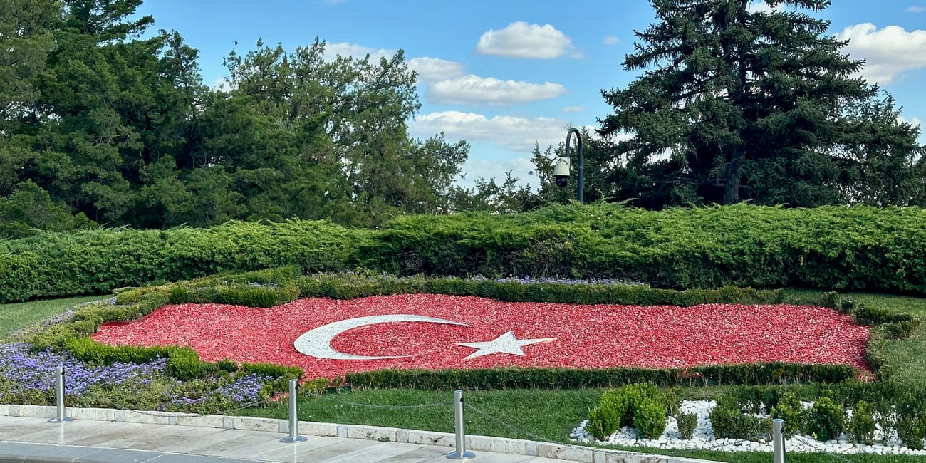 Turkey, ankara antikabir garden with a red floral turkish flag and white crescent star monument