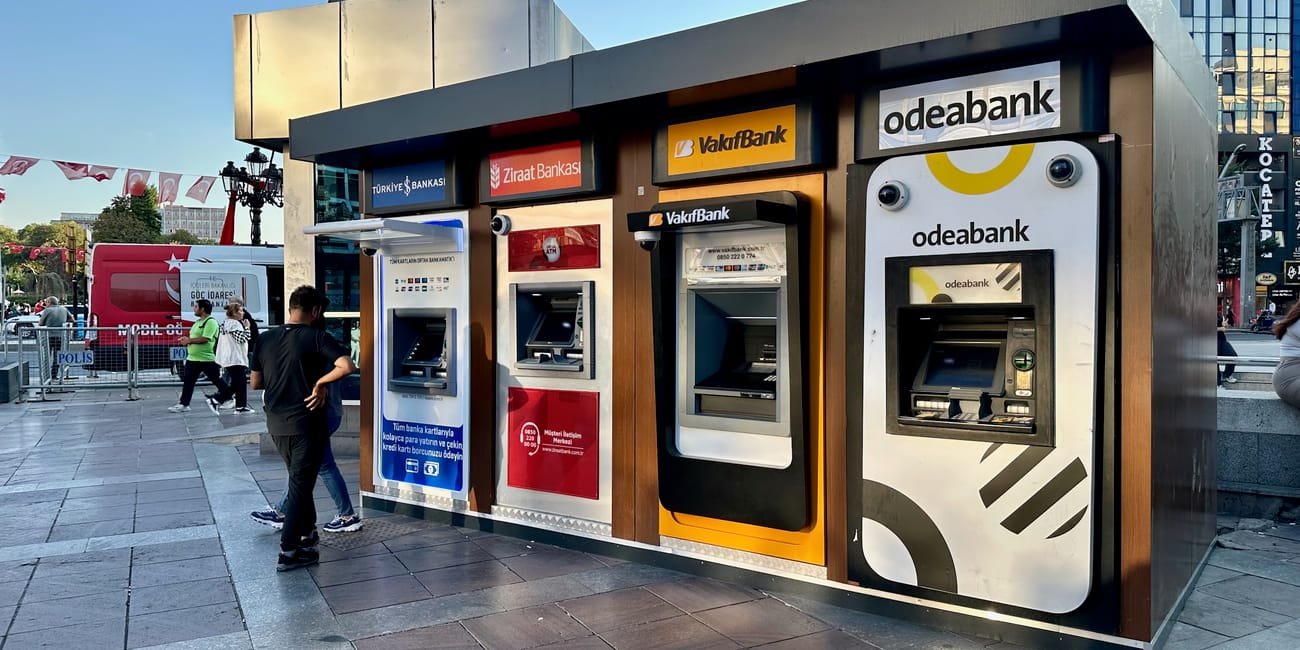 Bankomaty w ankarze z logo kilku tureckich banków na miejskim placu.