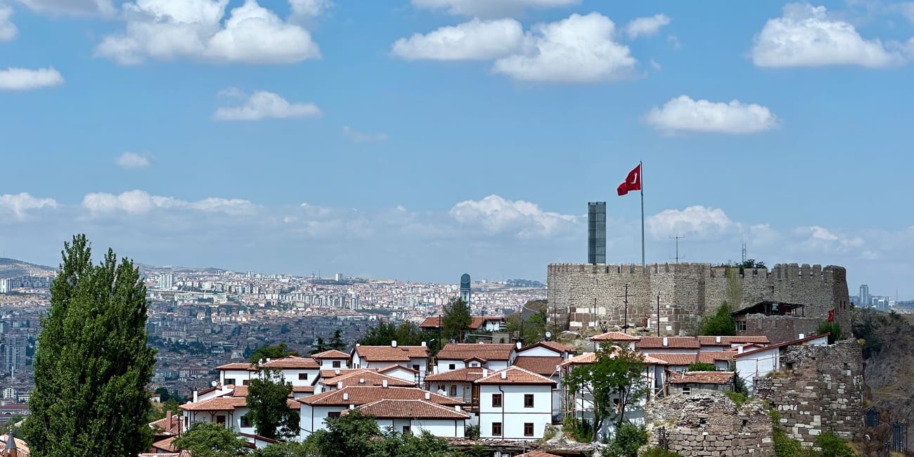 Turkey, ankara view from castle, overlooking a city skyline with a turkish flag on the fortress tower.