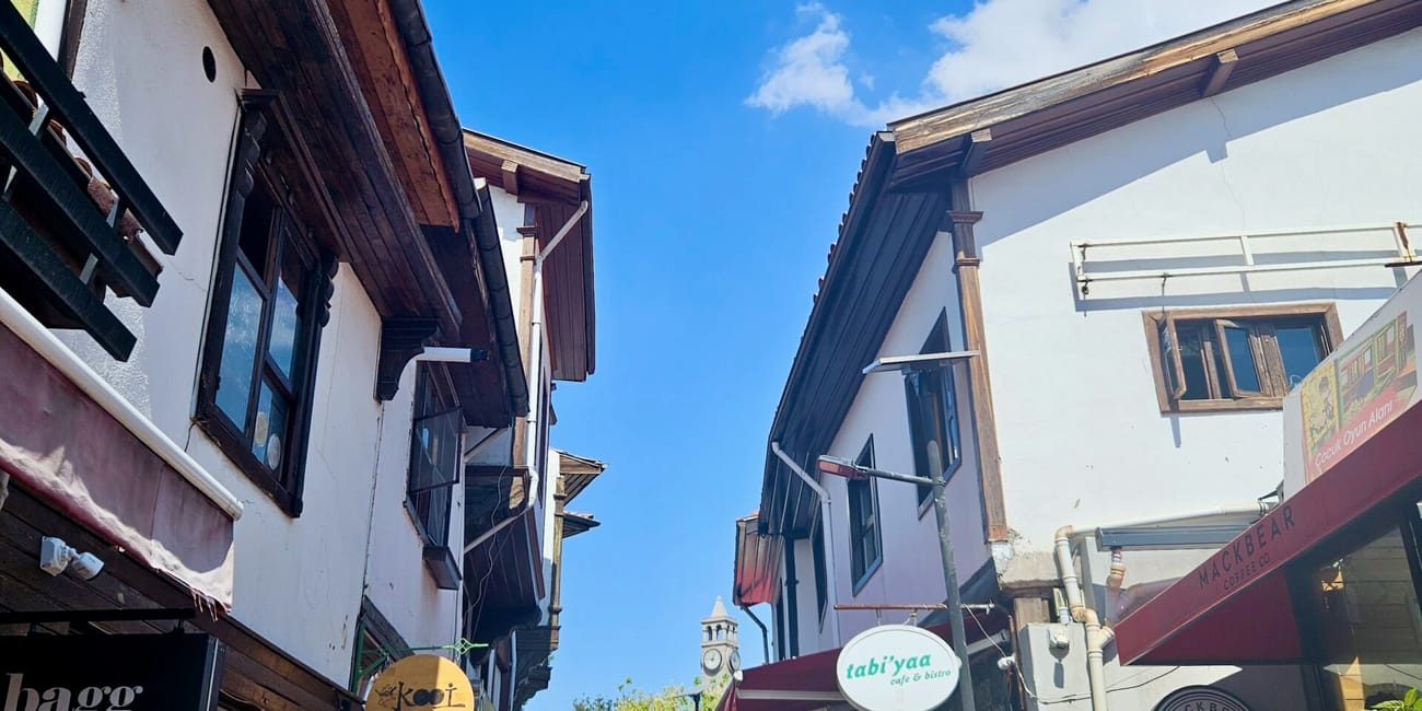 Ankara historical houses street with traditional ottoman-style facades, shops, and a blue sky overhead