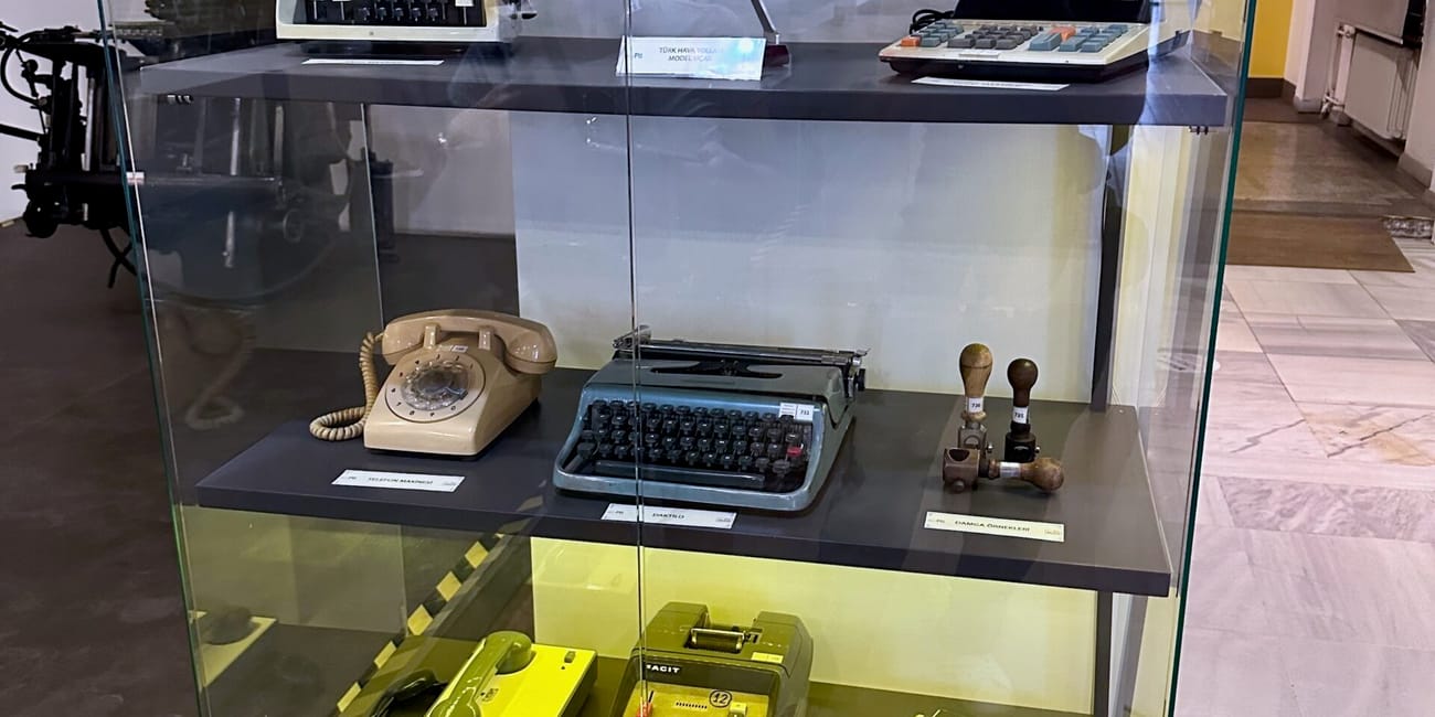 Turkey, ankara ptt stamp museum display case with vintage stamps, typewriters, and a model airplane