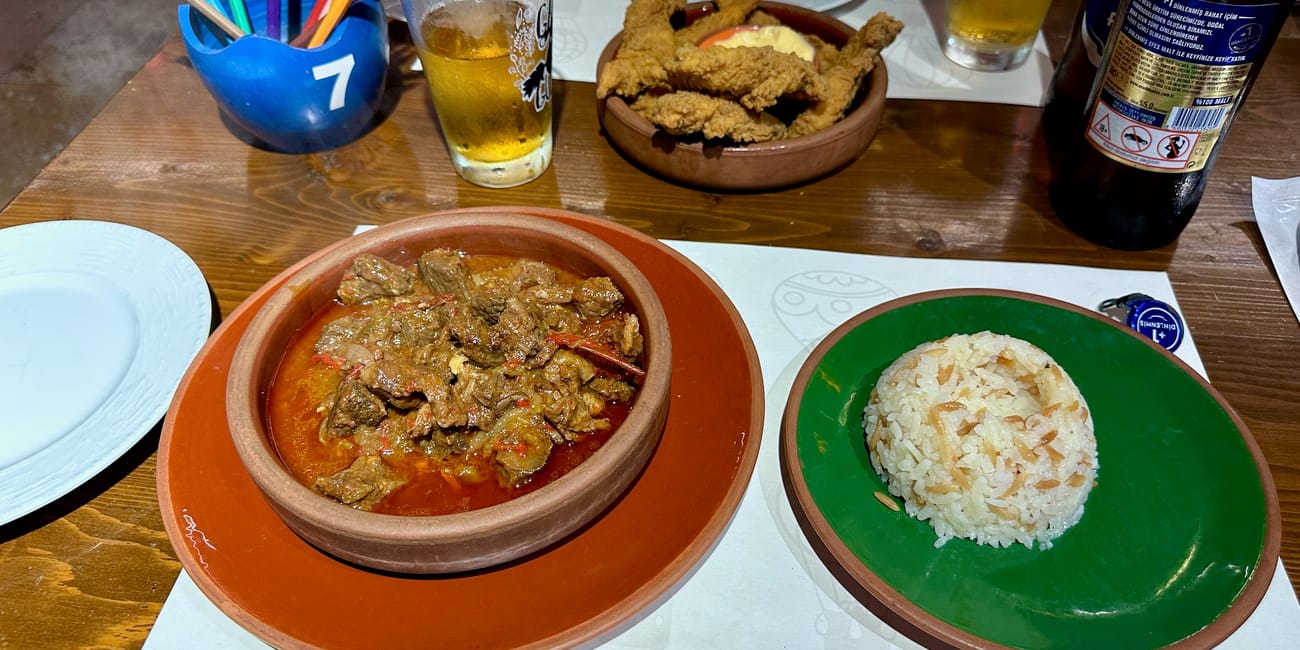 Posiłek w pals kitchen w goreme foods: duszone mięso, ryż i smażone przekąski przy piwie.