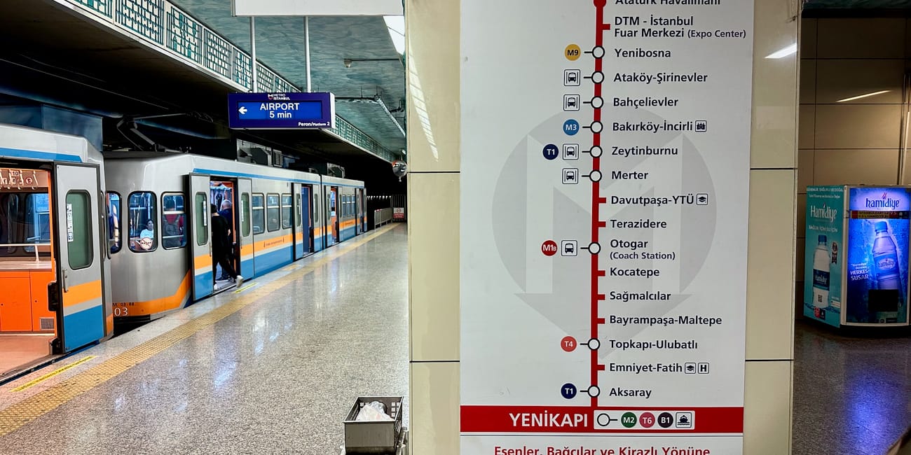 Peron metra w stambule z tablicą linii do lotniska atatürka i otwartym pociągiem.