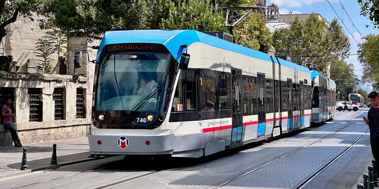 Nowoczesny tramwaj w stambule na torach przy ulicy, w słoneczny dzień.