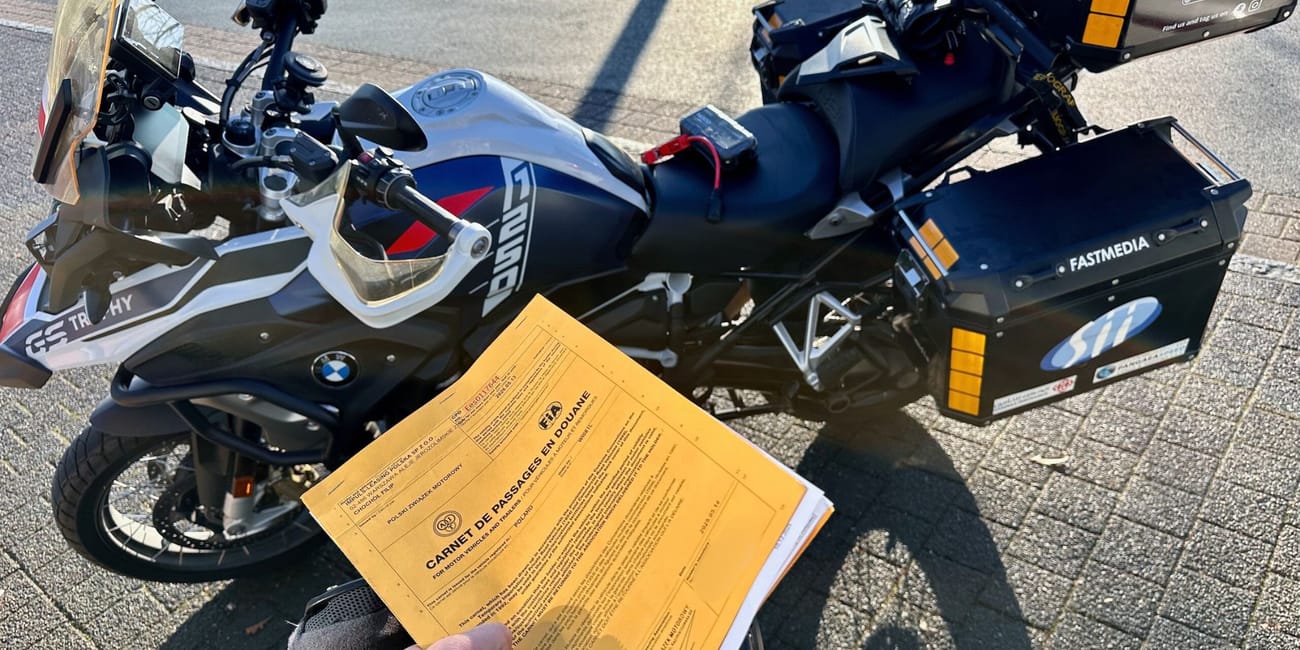Motorcycle at germany’s bremen motorcycle customs with a hand holding an open customs carnet document