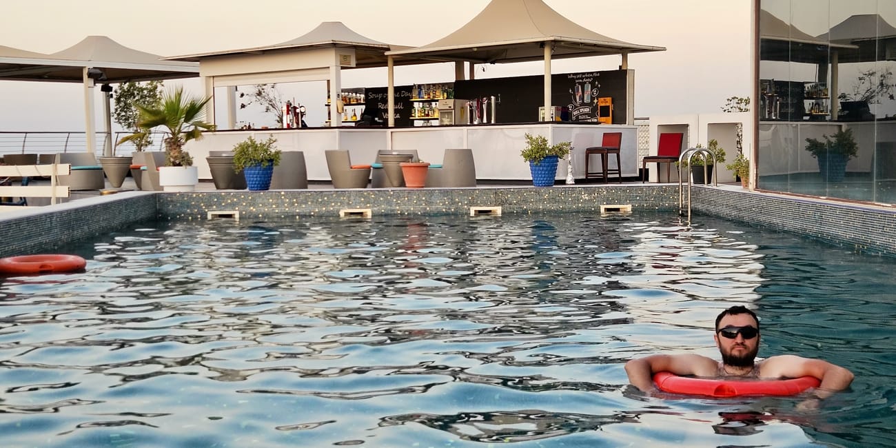 Muscat, oman – basen przy naszym noclegu z barem i mężczyzną na czerwonym kole w wodzie