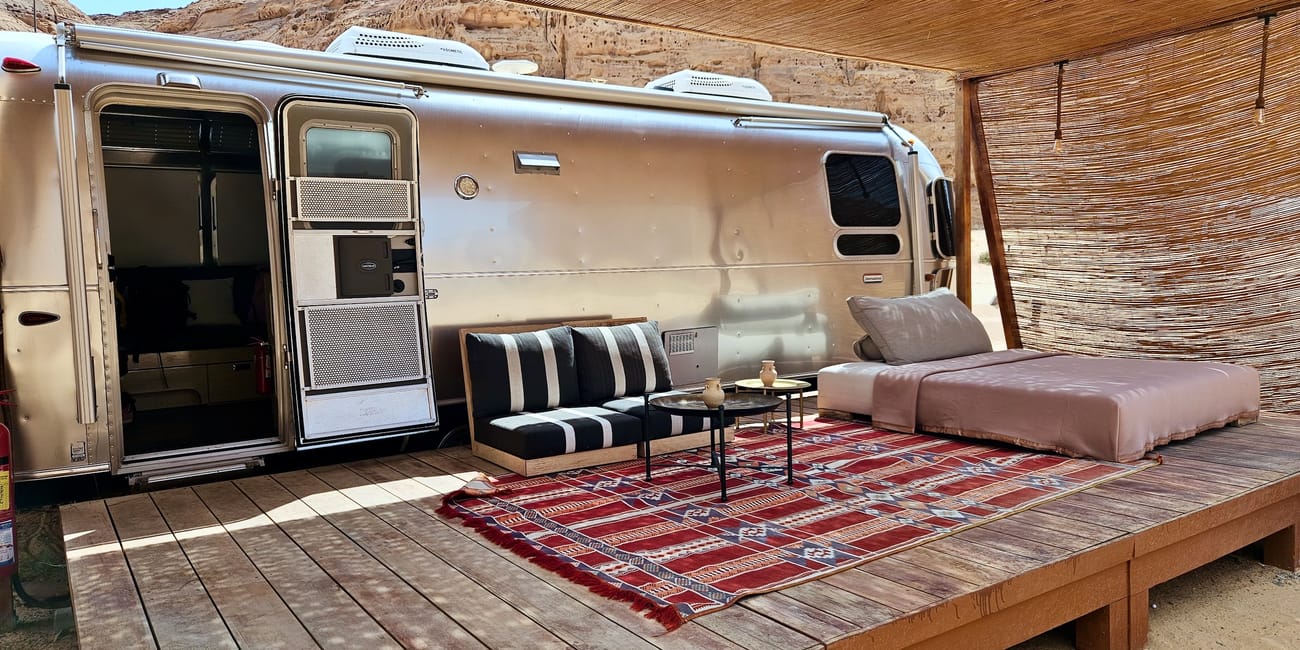 Al ula caravans by habitas in saudi arabia, open caravan with lounge seating and rugs under a canopy