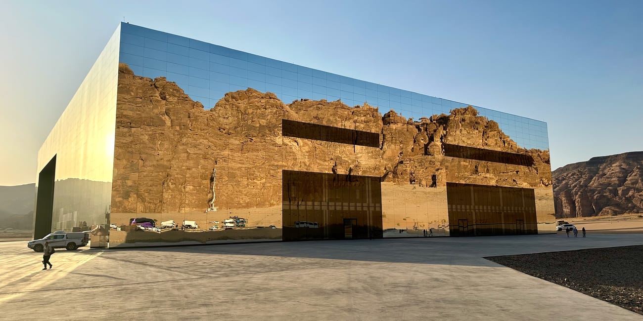 Saudi arabia, al ula maraya exterior building with reflective walls and desert cliffs at dusk