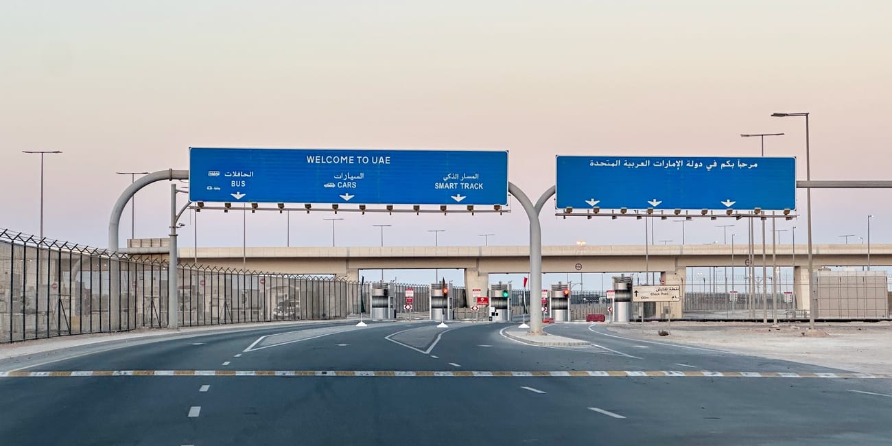 Wjazd drogowy na granicy lądowej z arabią saudyjską w uae z niebieskimi znakami welcome to uae над jezdnią