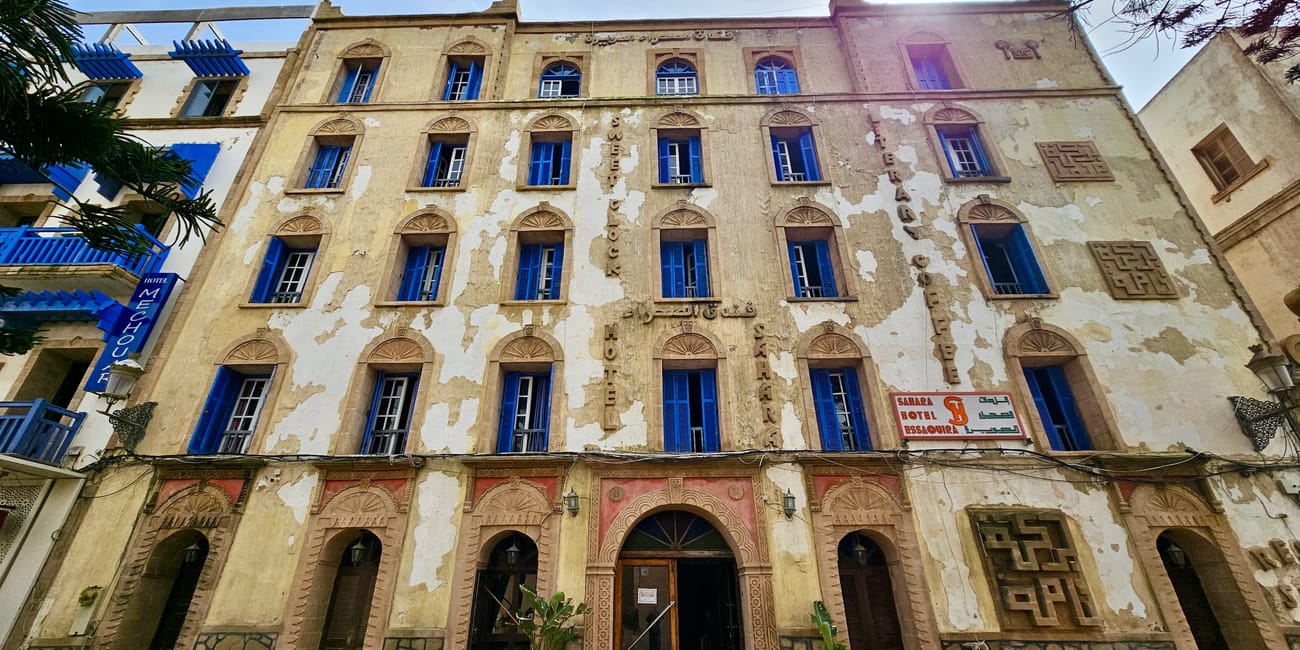 Essaouira, medina: zabytkowa fasada budynku hotelowego z oknami i szyldem sahara hotel essaouira