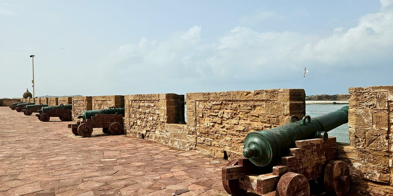 Maroko, essaouira: port — kamienne mury i zabytkowe działa artyleryjskie przy nabrzeżu.