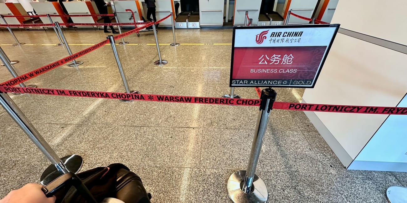 Kolejka do odprawy biznes klasy na lotnisku chopina w warszawie, z oznaczeniem air china i star alliance gold